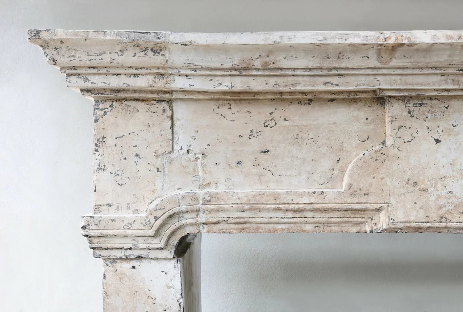 Detail of curved limestone fireplace leg showing 18th-century stone craftsmanship and authentic wear.