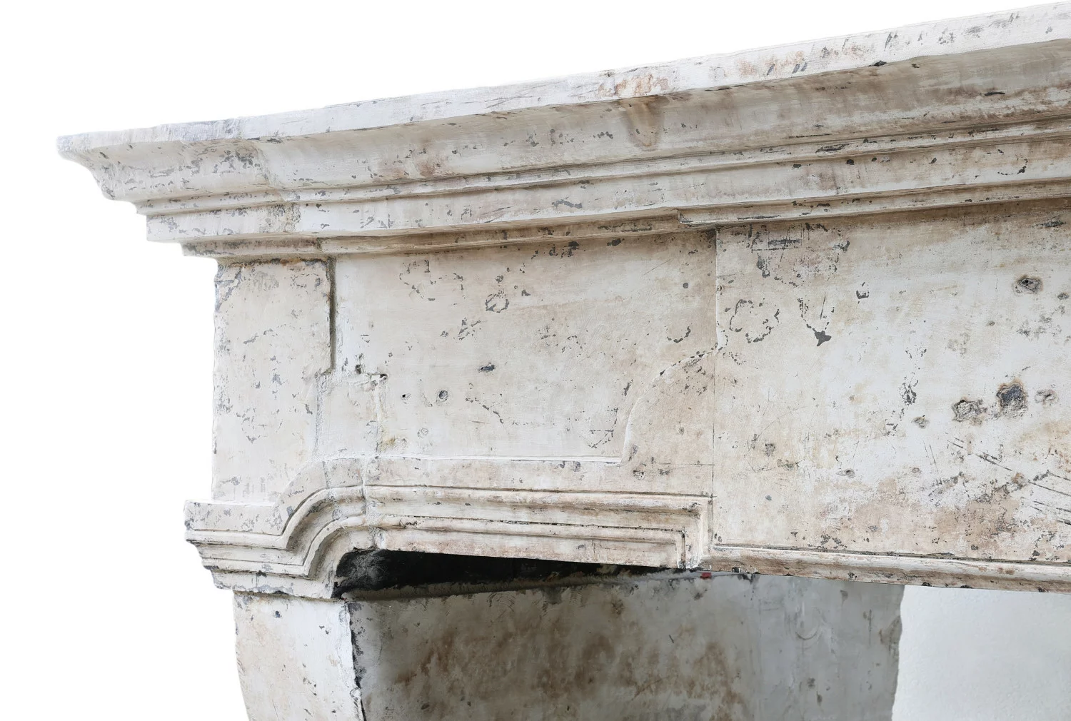 Close-up of 18th-century French limestone mantel frieze with carved mouldings and historic patina.