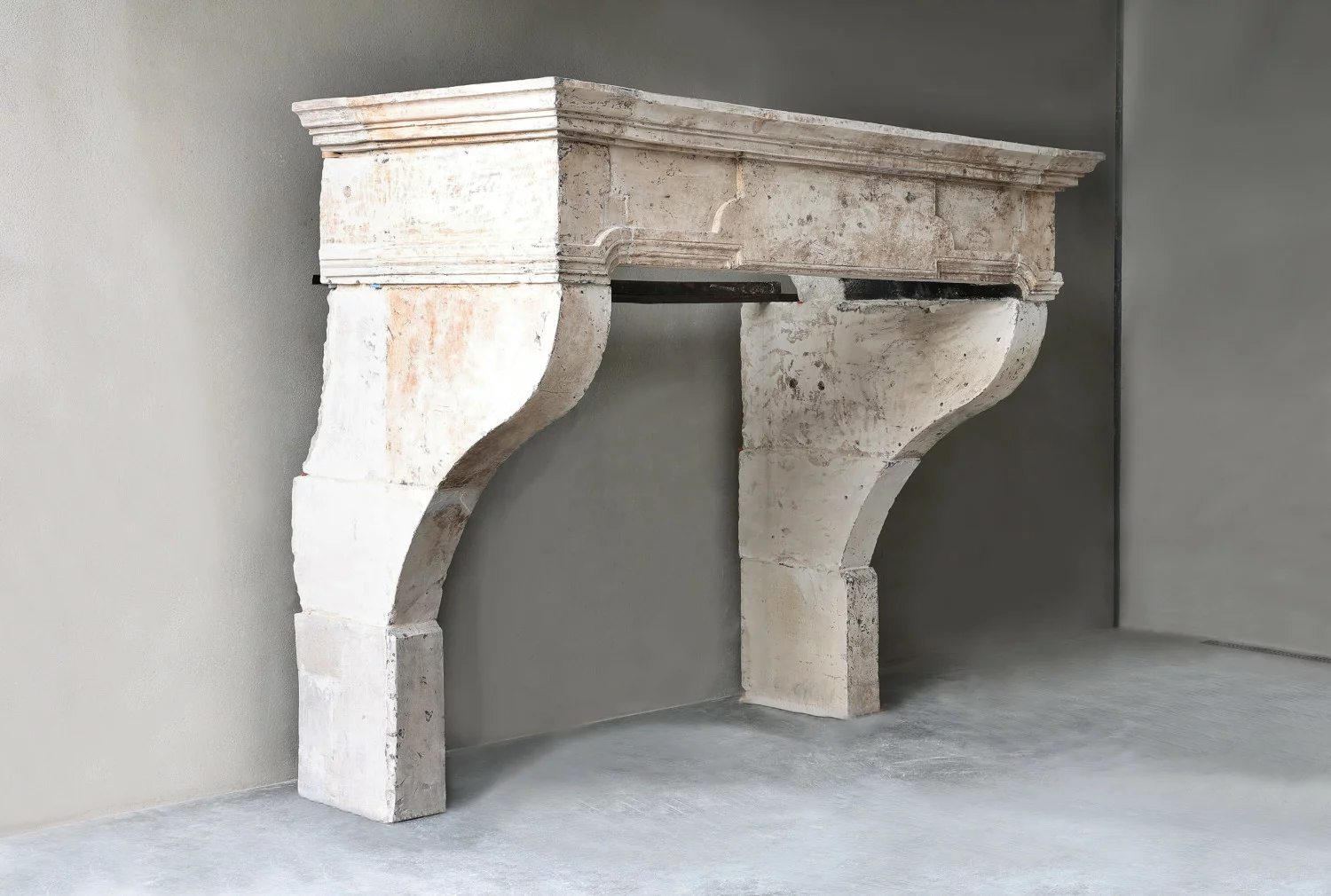 Side view of antique French limestone fireplace cornice with deep moulding and natural aged stone surface