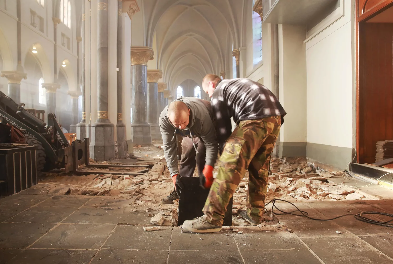 Stacked 44x44 cm reclaimed Belgian black limestone tiles after removal from the church in Klundert