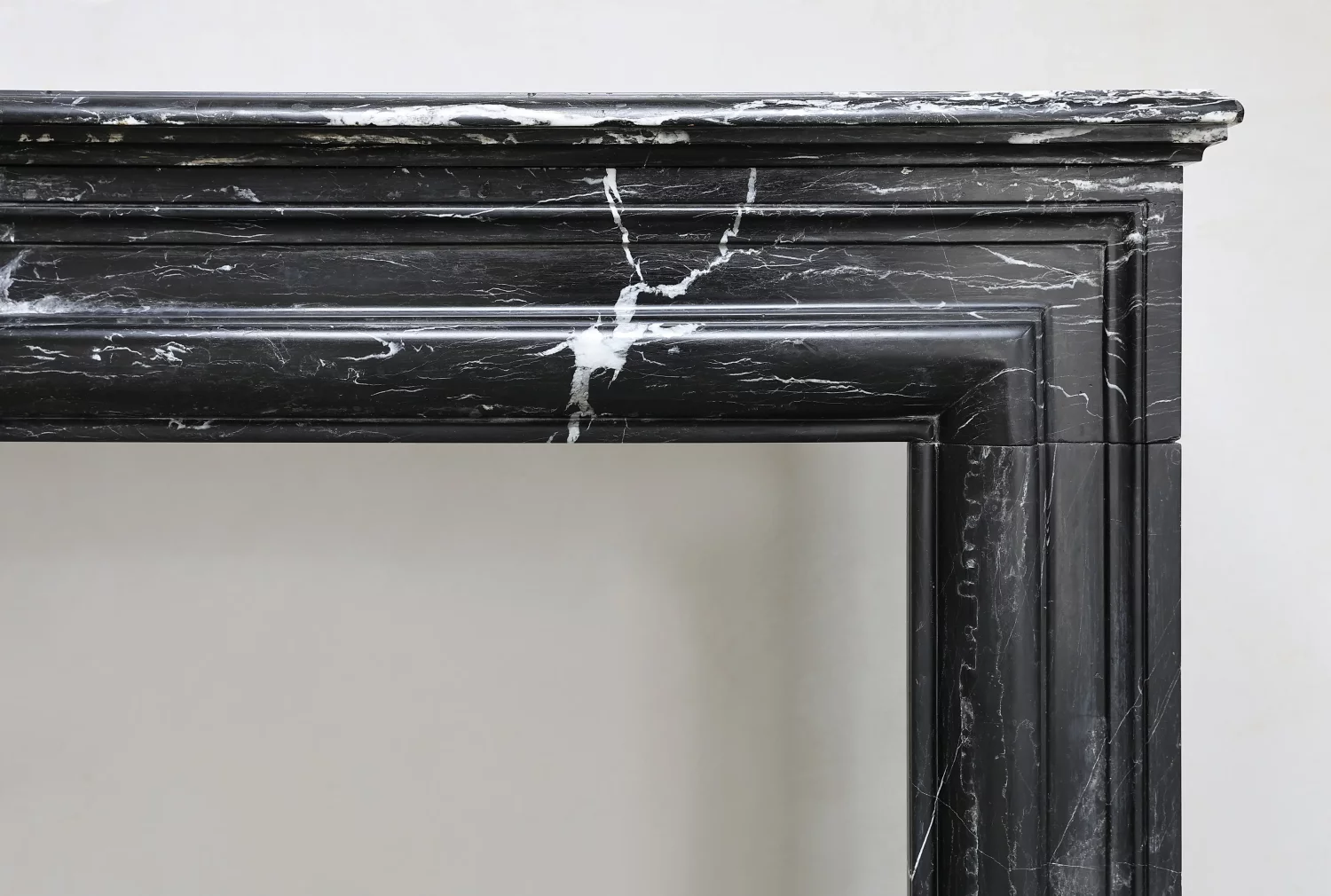 White veining across the lintel and right-hand corner of an antique Nero Marquina marble mantelpiece.